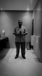 Full length of man standing in illuminated building