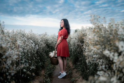 Full length of woman standing by tree