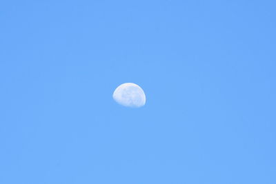 Low angle view of moon against blue sky