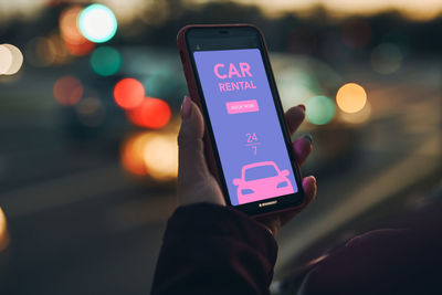 Woman renting car online using mobile app on smart phone. person booking car using mobile phone