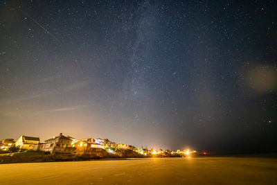 Illuminated buildings against sky at night