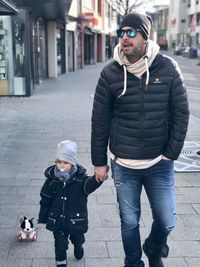 Portrait of friends standing on street in city