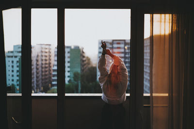 Rear view of woman standing in balcony