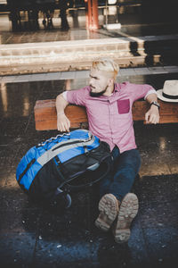 Man with backpack sitting on floor