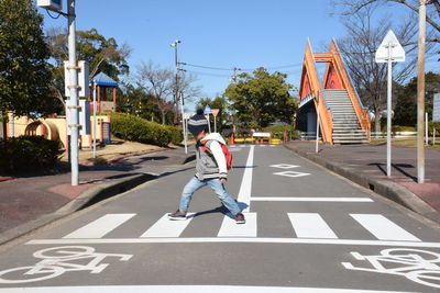 Rear view of woman walking on road