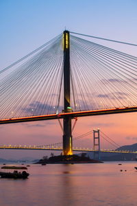 Low angle view of suspension bridge against sky at sunset