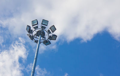 Low angle view of floodlight against cloudy sky