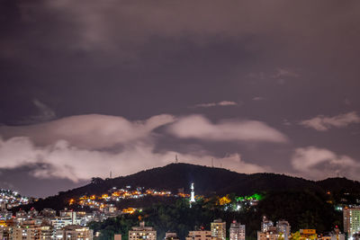 Illuminated city against sky at night