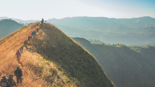 Rear view of people on mountain against sky