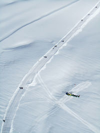 Aerial view of helicopter and people on snow covered field