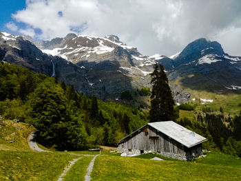 Scenic view of house and mountains against sky