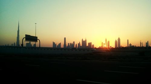 Skyscrapers in city at sunset