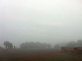 Scenic view of landscape against sky during foggy weather