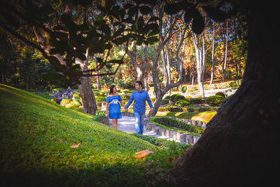 Rear view of people walking on field