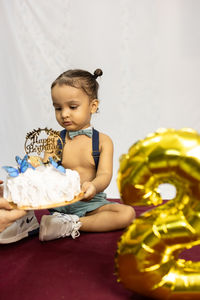 Indian baby boy happy moments at birthday celebration with white background at indoor