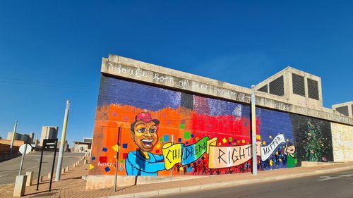 Graffiti on wall against blue sky