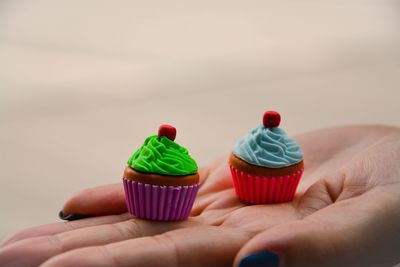 Cropped hand of woman holding small muffins