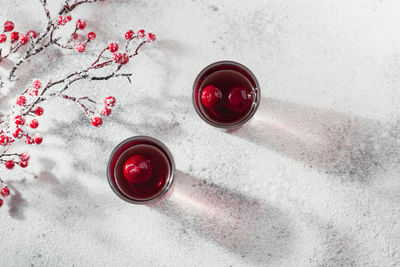 Two glasses of cherry liqueur on white background