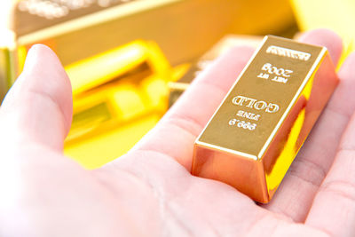 Close-up of hand holding gold bar