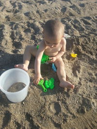 High angle view of boy playing with toy on sand