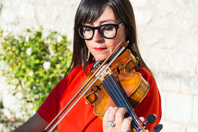 Woman playing violin outdoors