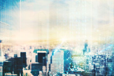 Defocused image of modern buildings against sky seen through glass window