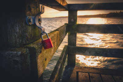 Padlocks hanging on railing by sea