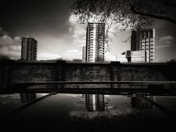 Bridge over river in city against sky