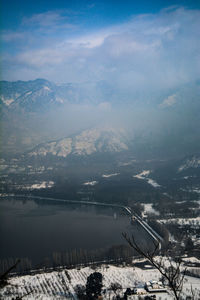 Aerial view of lake by mountains against sky