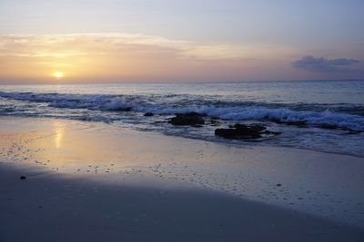 Scenic view of beach against sky during sunset