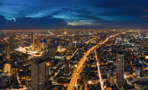 High angle view of illuminated city against sky at night