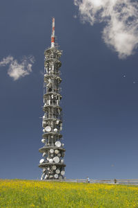 Lighthouse on field against sky