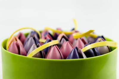 Close-up of multi colored drinking straws against white background