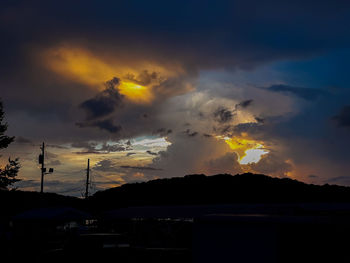 Silhouette mountains against dramatic sky during sunset