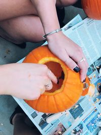 Cropped image of woman making jack o lantern