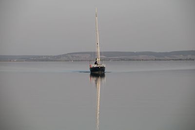 Sailboat in sea against clear sky