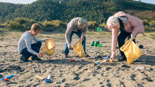 Group of senior volunteers picking up trash on the beach