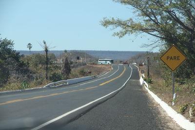 Road amidst trees against clear sky