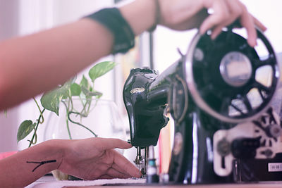 Cropped image of hands sewing on machine