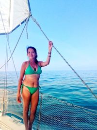 Full length of woman on beach against clear blue sky