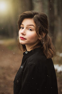 Portrait of beautiful young woman standing in forest