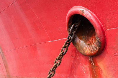 Close-up of rusty chain on red boat