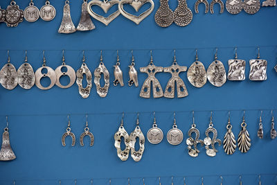 Earrings against blue wall