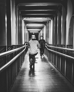 Rear view of man walking in corridor of building