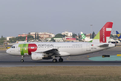 Airplane on airport runway against sky