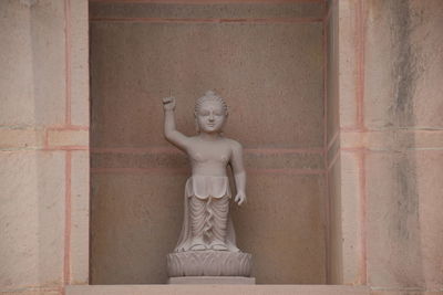 Statue of buddha against wall