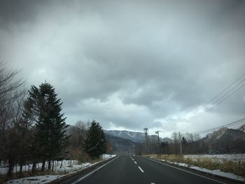 Empty road against cloudy sky