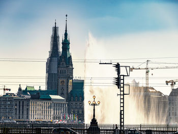 Low angle view of water fountain against hamburg rathaus