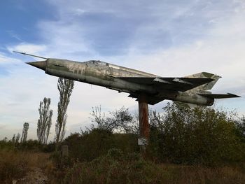 Low angle view of old bridge on field against sky