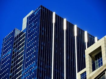 Low angle view of modern building against blue sky